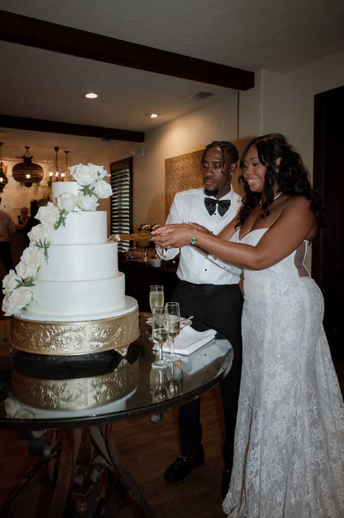 bride and groom cutting white wedding cake at Dallas wedding venue