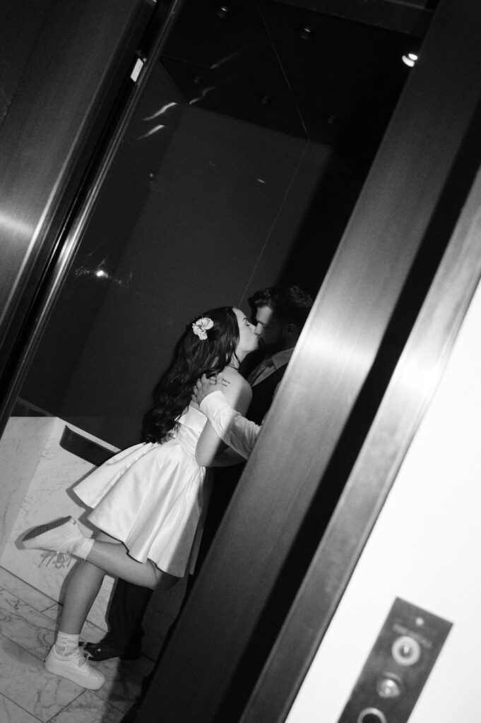 photo of bride and groom kissing in the elevator