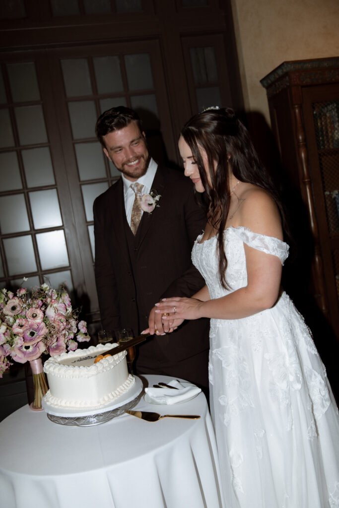 photo of bride and groom cutting vintage wedding cake taken by Texas Wedding Photographer
