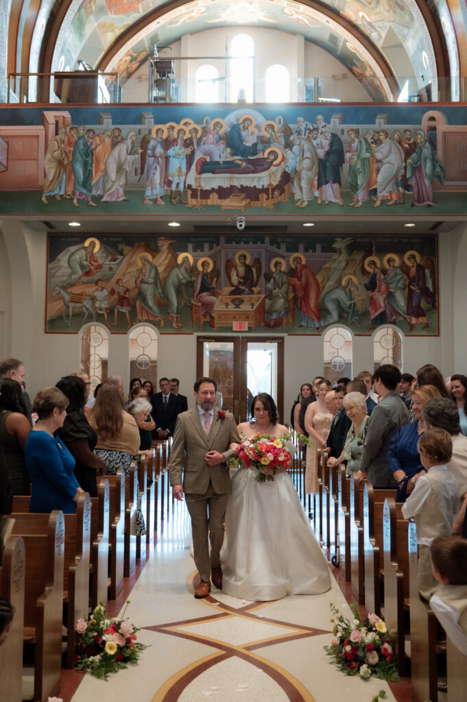 photo of bride walking down the aisle at her Greek Orthodox wedding ceremony
