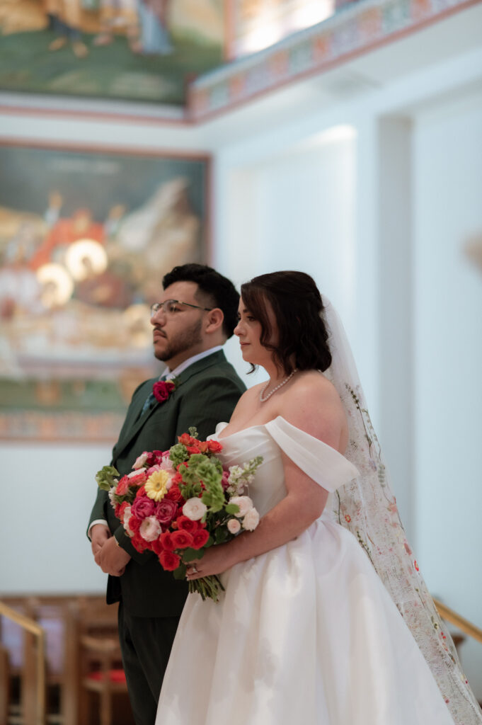 bride and groom standing together during Greek Orthodox Wedding ceremony
