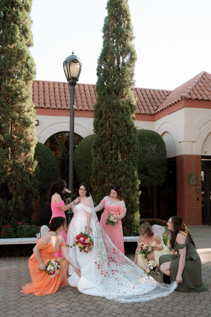 photo of bride being dotted on by bridesmaids